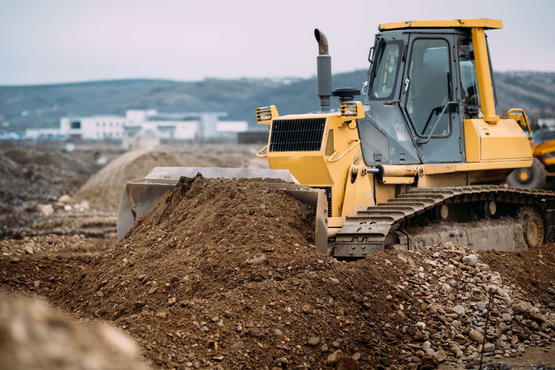 Bulldozer weight in action: Heavy-duty crawler dozer pushing dirt at construction site with visible blade and crawler tracks.